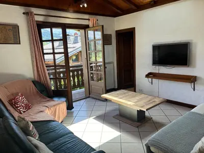 a living room with a couch and a table and a tv at Le Mont - Vue montagne - Parking - Wifi - Nature in Demi-Quartier