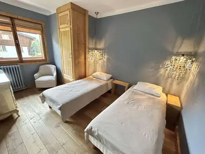 a room with two beds and a chair in it at Appartement 4 pièces, 6 couchages, balcon, parking, Megève - FR-1-597-194 in Megève