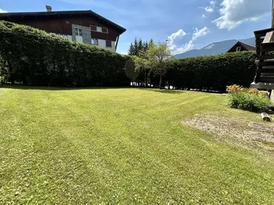 a large grassy yard with a house in the background at Appartement 4 pièces, 6 couchages, balcon, parking, Megève - FR-1-597-194 in Megève