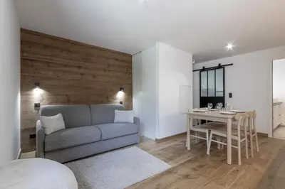a living room with a couch and a table at Studio Kayla - Espace bien-etre Piscine Face au Kandahar in Les Houches