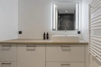 a white bathroom with a sink and a mirror at Studio Kayla - Espace bien-etre Piscine Face au Kandahar in Les Houches