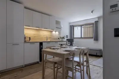 a kitchen and dining room with a table and chairs at Studio Kayla - Espace bien-etre Piscine Face au Kandahar in Les Houches