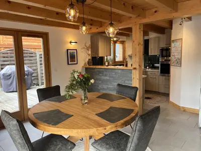 a dining room with a wooden table and chairs at Chalet Alpéa - Jacuzzi vue montagne - Neuf in Saint-Gervais-les-Bains