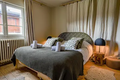 a bedroom with a bed with towels on it at Au Bord de leau Ski & ete en famille in Megève