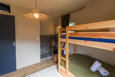 a room with two bunk beds and a chandelier at Au Bord de leau Ski & ete en famille in Megève