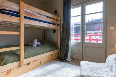 a bunk bed in a room with a window at Au Bord de leau Ski & ete en famille in Megève