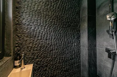 a bathroom with a shower with a wicker wall at Au Bord de leau Ski & ete en famille in Megève
