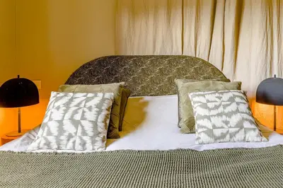 a bed with two pillows on top of it at Au Bord de leau Ski & ete en famille in Megève