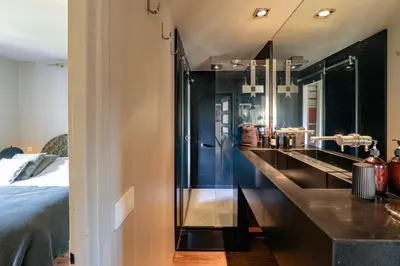 a bathroom with black counters and a bed in a room at Au Bord de leau Ski & ete en famille in Megève