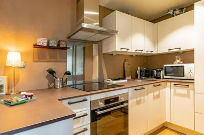 a kitchen with white cabinets and a microwave at Arly in Megève