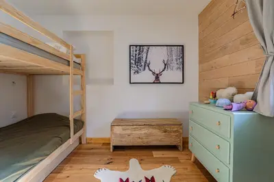 a childs bedroom with a bunk bed and a dresser at Cocoon - Jardin privé au cœur de Megève in Megève