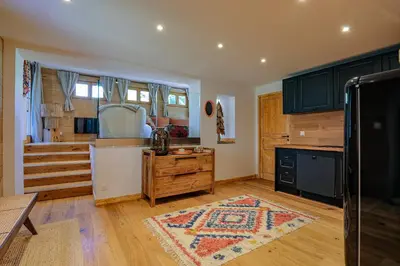 a kitchen with green cabinets and a rug on the floor at Cocoon - Jardin privé au cœur de Megève in Megève