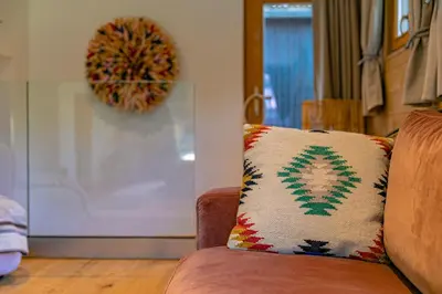a couch with a pillow on it in a living room at Cocoon - Jardin privé au cœur de Megève in Megève
