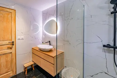 a bathroom with a sink and a glass shower at Cocoon - Jardin privé au cœur de Megève in Megève