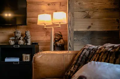 a living room with a leather couch and a lamp at Le Duplex in Megève