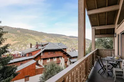 a view from the balcony of a house with a table at Le Duplex in Megève