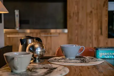 a wooden table with two cups and a tea kettle at Le Duplex in Megève
