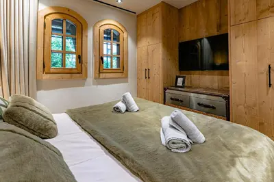 a bedroom with a large bed with towels on it at Escapade in Megève