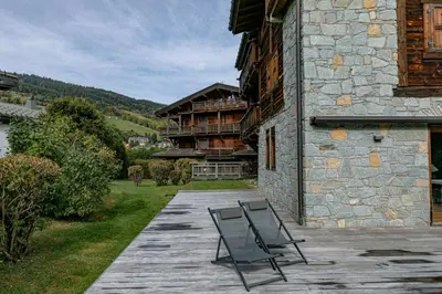 a couple of chairs sitting on a deck next to a building at Escapade in Megève