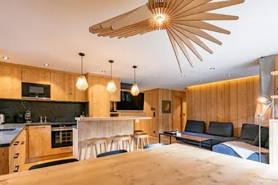 a kitchen and living room with a ceiling fan at Escapade in Megève