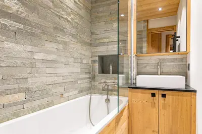 a bathroom with a bath tub and a sink at Escapade in Megève