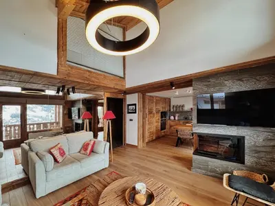 a living room with a couch and a fireplace at Les Mesanges in Megève