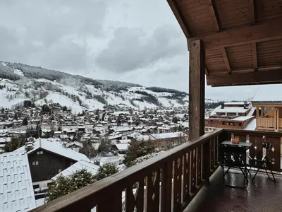 a balcony with a view of a town in the snow at Les Mesanges in Megève