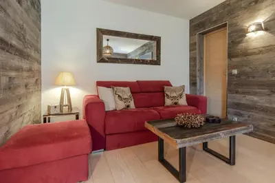 a living room with a red couch and a table at Red Touch - Balcon vue et confort en famille in Megève