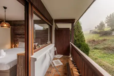 a room with a balcony with a bed and a window at Red Touch - Balcon vue et confort en famille in Megève