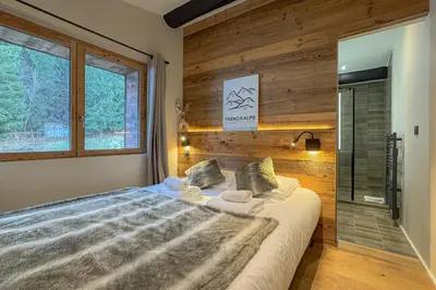 a bedroom with a large bed and a window at Le Black Wood in Demi-Quartier