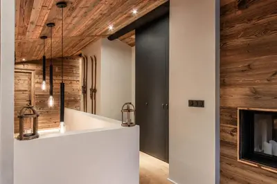 a kitchen with a white counter and a fireplace at Le Black Wood in Demi-Quartier