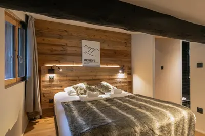 a bedroom with a large bed with a wooden wall at Le Black Wood in Demi-Quartier