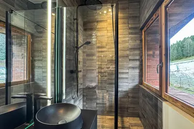 a bathroom with a tub and a sink and a shower at Le Black Wood in Demi-Quartier