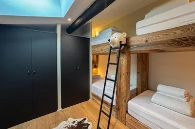 a bunk bedded room with a ladder and a bunk bed at Le Black Wood in Demi-Quartier