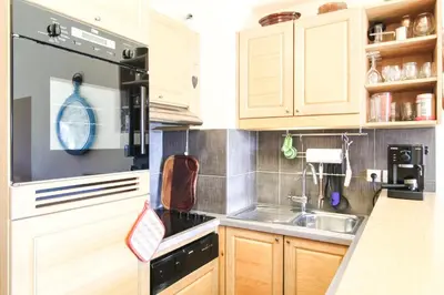a kitchen with wooden cabinets and a stove top oven at Residence Terrasses Eos, T2 48m2 Sud, Vue Montagne, avec Cheminee, Parking, Piscine in Flaine