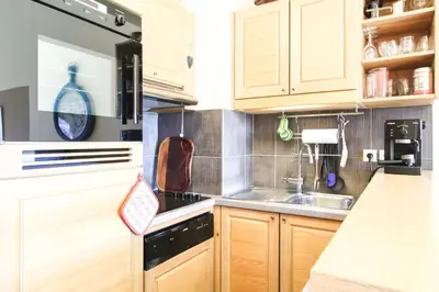 a kitchen with wooden cabinets and a sink at Residence Terrasses Eos, T2 48m2 Sud, Vue Montagne, avec Cheminee, Parking, Piscine in Flaine