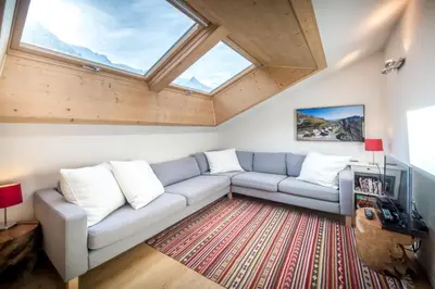 a living room with a couch and a window at Rupicapra apartment - Chamonix All Year in Chamonix-Mont-Blanc