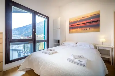 a bedroom with a white bed with two towels on it at Rupicapra apartment - Chamonix All Year in Chamonix-Mont-Blanc