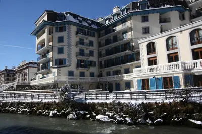 a large white building next to a river at Residence des Alpes 302 appt - Chamonix All Year in Chamonix-Mont-Blanc