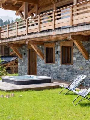 a house with a pool and a deck and two chairs at Chalet Victory I Le Chalet Club in Combloux