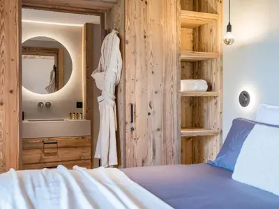 a bedroom with a bed and a sink and a mirror at Chalet Victory I Le Chalet Club in Combloux