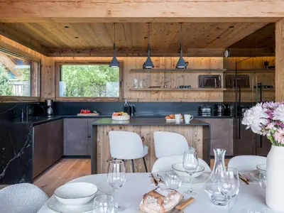 a kitchen with a table and chairs in a room at Chalet Victory I Le Chalet Club in Combloux