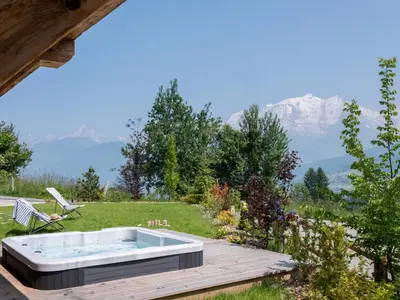 a hot tub on a deck with mountains in the background at Chalet Victory I Le Chalet Club in Combloux