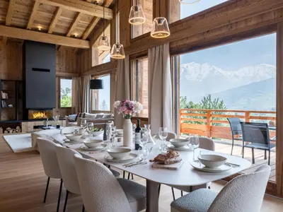 a dining room with a table and chairs and a large window at Chalet Victory I Le Chalet Club in Combloux