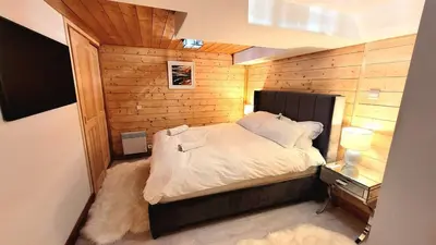 a bedroom with a bed in a room with wooden walls at Ski in Ski out MNT Direct piste access in Les Houches