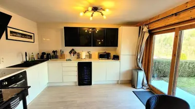 a kitchen with white cabinets and a ceiling at Ski in Ski out MNT Direct piste access in Les Houches