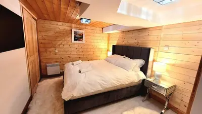 a bedroom with a bed in a wooden wall at Ski in Ski out MNT Direct piste access in Les Houches