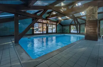 a large swimming pool with a wooden ceiling at Ski in Ski out MNT Direct piste access in Les Houches