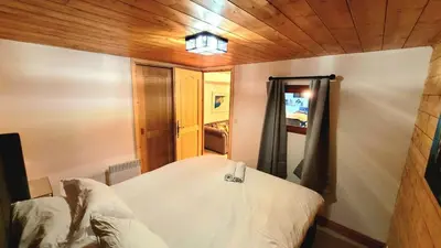 a small room with a bed with a mirror at Ski in Ski out MNT Direct piste access in Les Houches