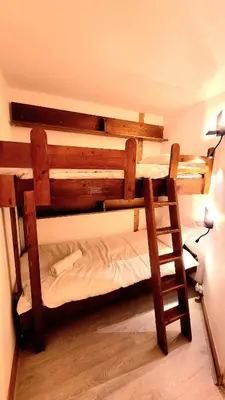 a bedroom with two bunk beds and a ladder at Ski in Ski out MNT Direct piste access in Les Houches